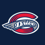 Team logo for 'Drive' featuring a gray wing across a red circular ring on a dark blue background