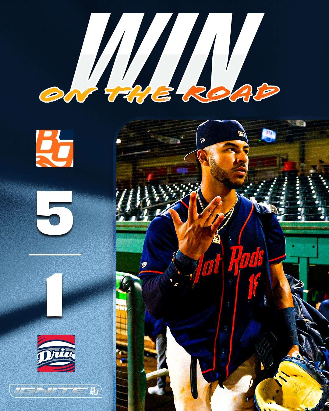 Baseball player in a blue jersey and cap walks out from the dugout on a promotional poster that reads 'WIN ON THE ROAD' at the top.