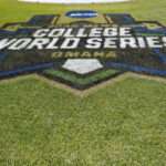 College World Series logo painted in turf on a baseball field, with green grass surrounding it.