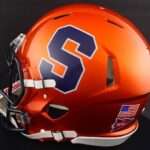 Orange football helmet with a large blue Syracuse 'S' logo, white facemask, and NCAA sticker.