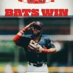 Baseball player in a blue uniform saluting with a large red 'BATS WIN' headline above him.