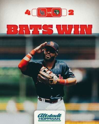 Baseball player in a blue uniform saluting with a large red 'BATS WIN' headline above him.