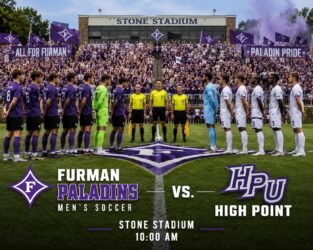Furman Paladins vs. High Point men’s soccer teams line up on the field at Stone Stadium as fans watch in purple.
