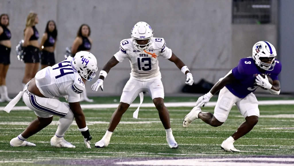 ACU running back Rovaughn Banks Jr slips away from SFA defensive lineman Kaiden Turner (left) and cornerback Aaron Sears Saturday Sept. 6, 2025. Abilene Christian University defeated Stephen F. Austin University at home, 28-20.